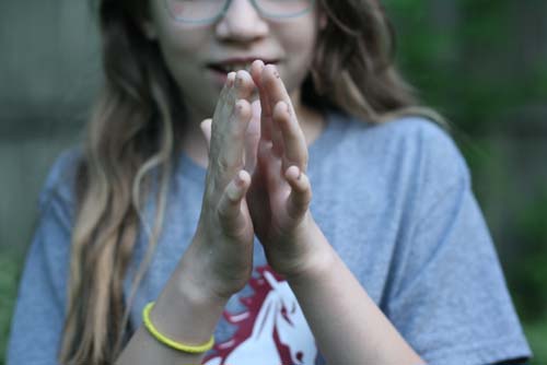 Girl with hands pressed together in prayer